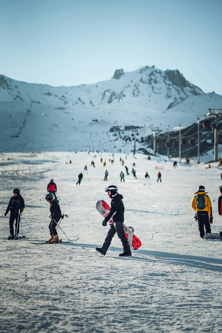 Skiers and snowboarders on a snowy mountain slope during winter, capturing a vibrant ski holiday scene.